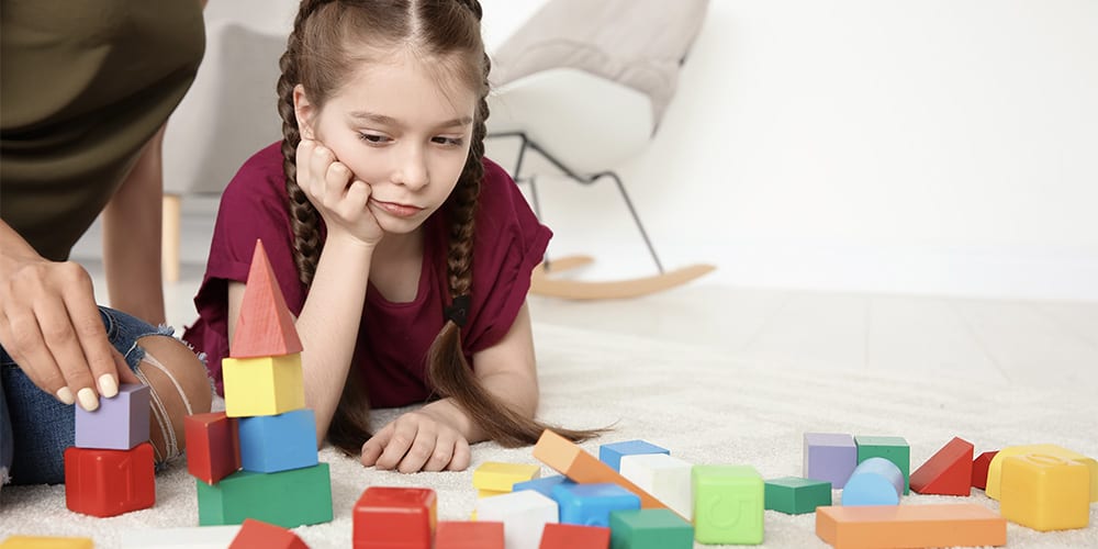 A female child playing with colorful blocks