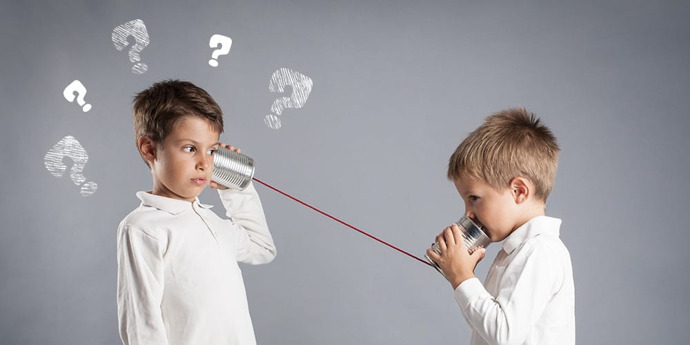 Two child talking over cans with a string