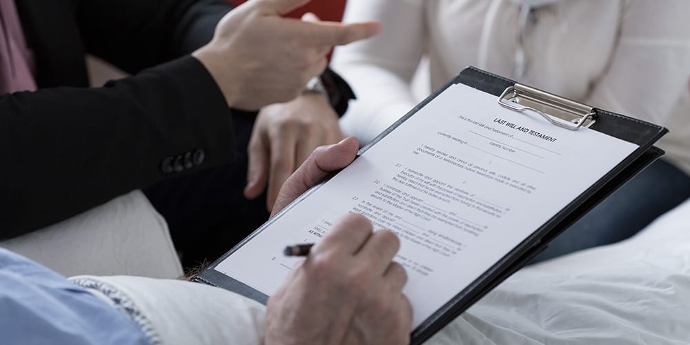 Man signing last will with lawyer