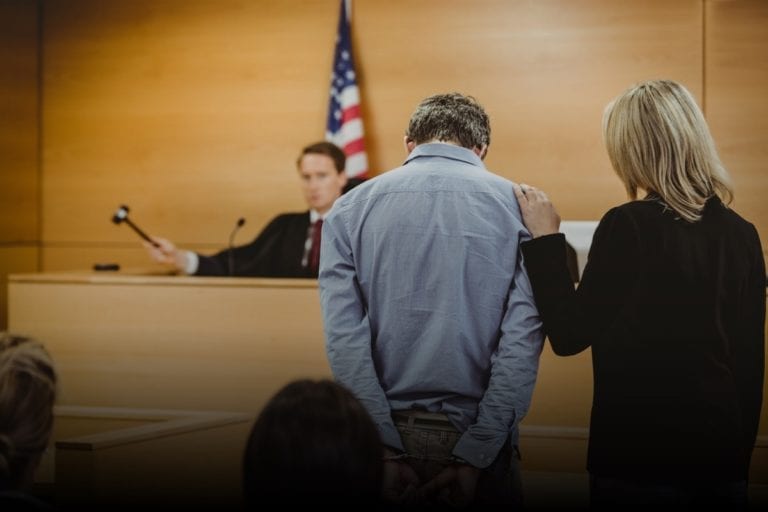 Handcuffed man and lawyer in a courtroom