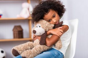Child Holding Teddy Bear During Neuropsychological Evaluation